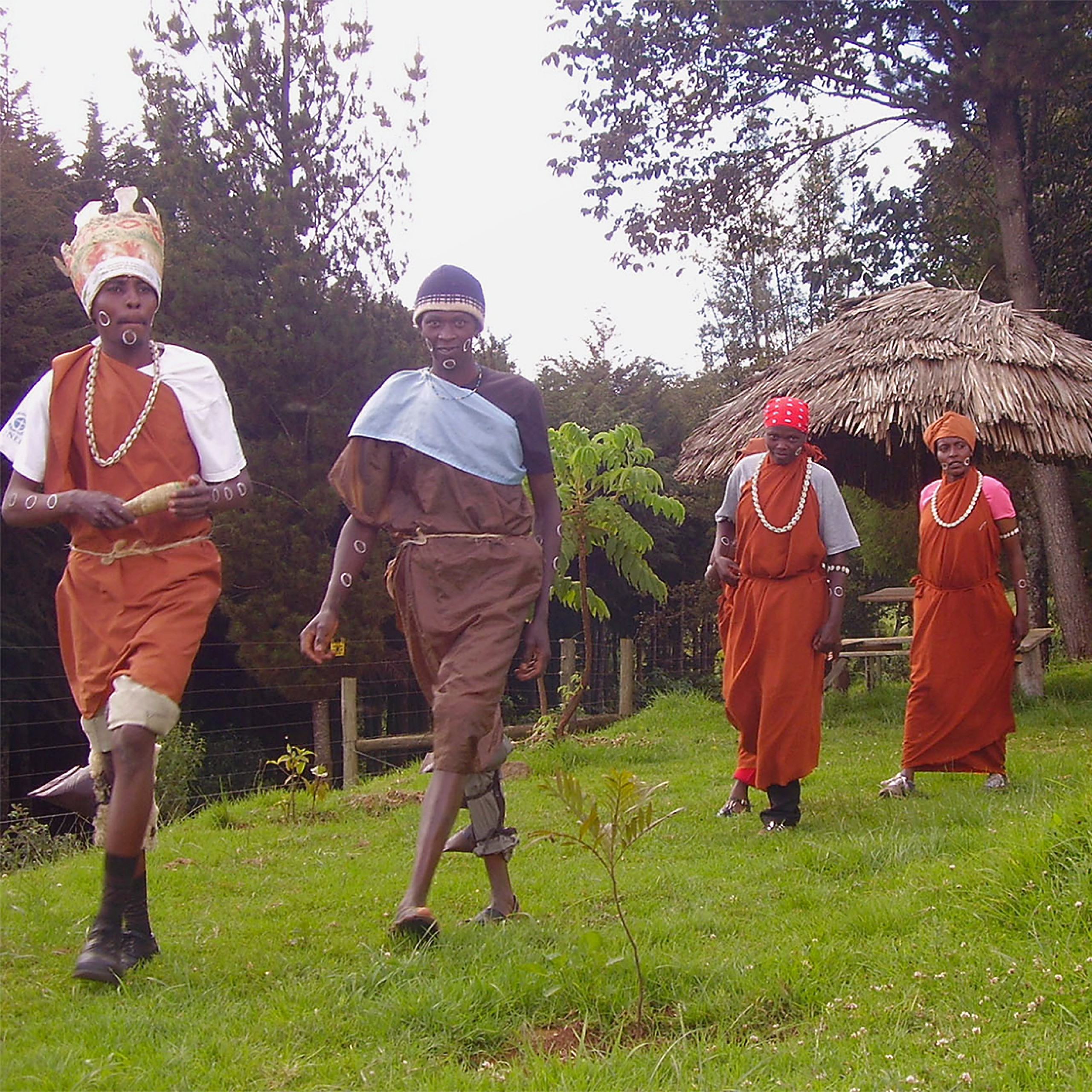 Personnes en tenue traditionnelle Kikuyu marchant dans un jardin au Kenya.