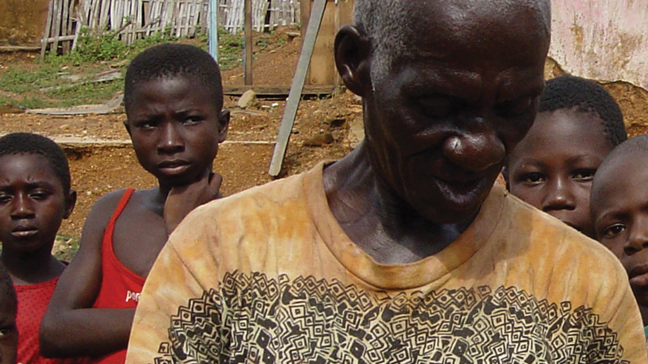 Close-up on an elderly man and four children behind him in Ghana