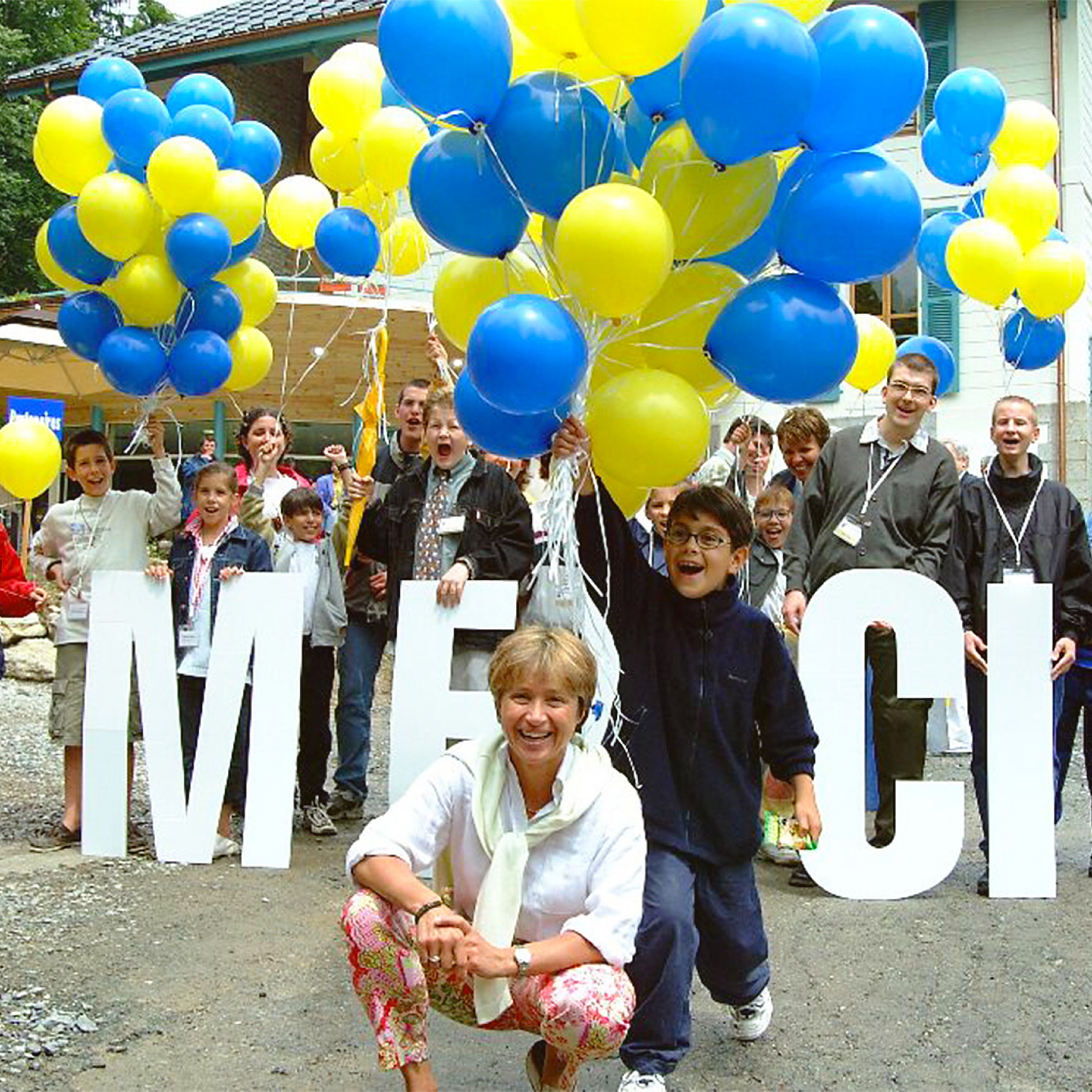 Photo de groupe réunissant des adultes et des enfants avec des ballons de baudruche
