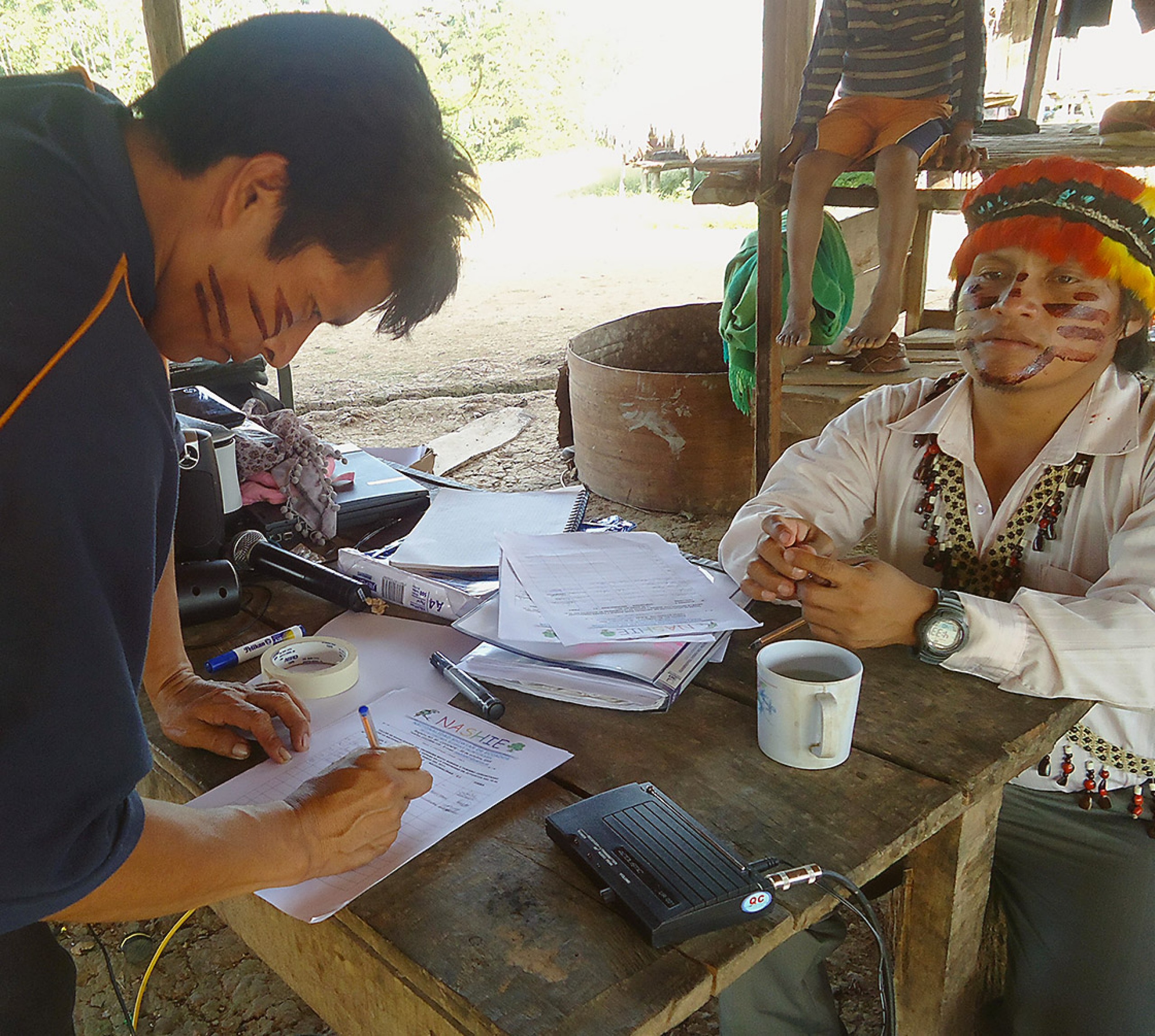 Deux indigènes remplissent un document en Equateur.