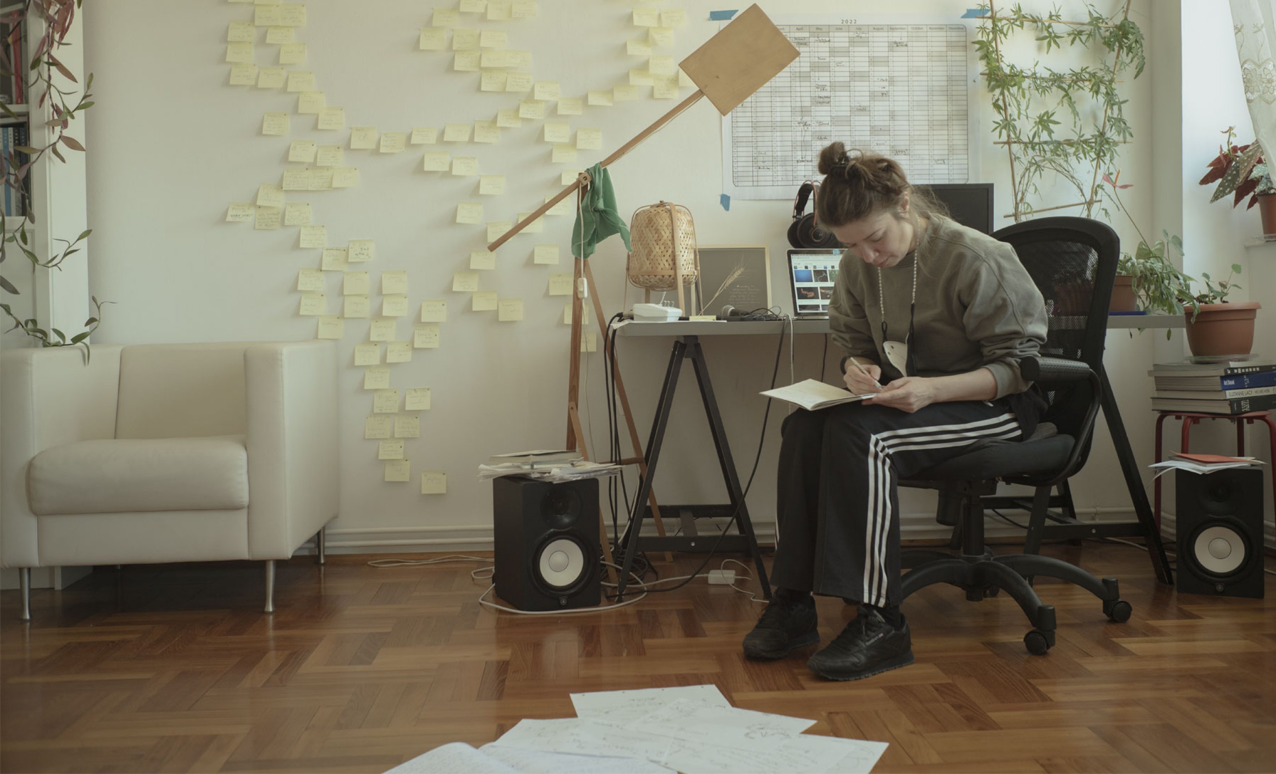 Alexandra Pirici écrivant dans un cahier à son bureau