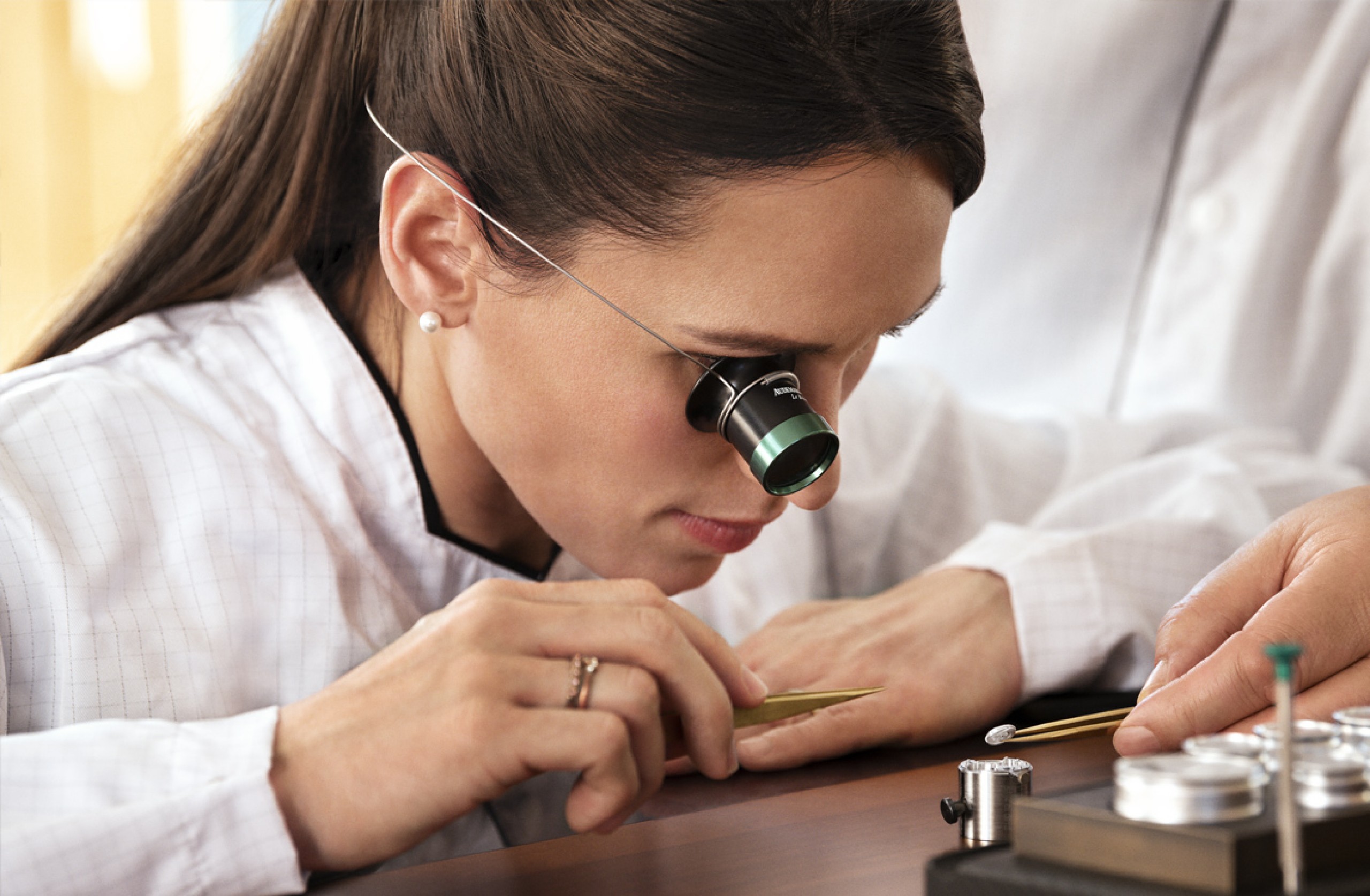 A woman dressed as a watchmaker working on a mechanism